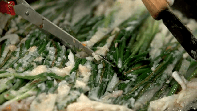 철판에서 가위로 자르는 해물파전