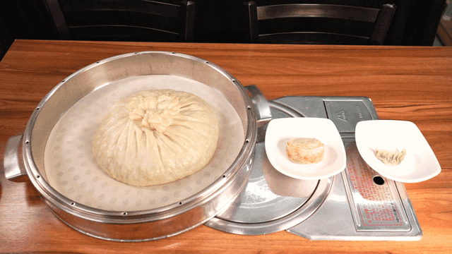 Steamed dumplings of various sizes on table