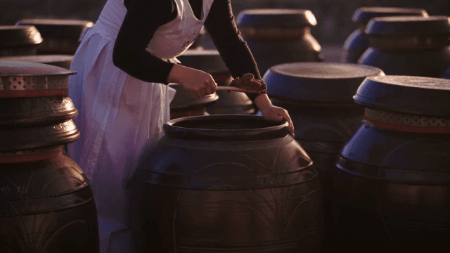 장독대에서 장을 퍼내는 사람