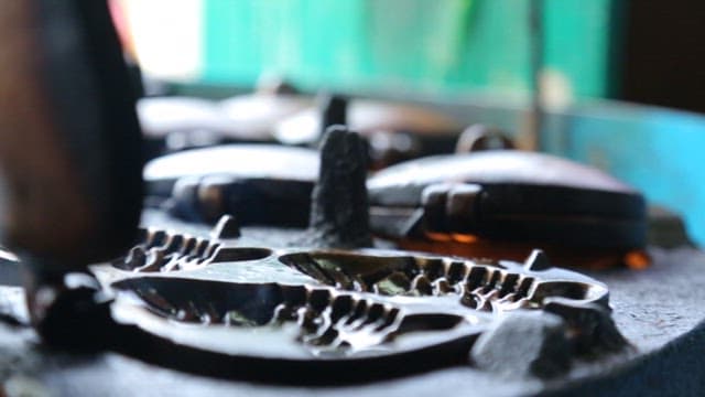 뜨거운 붕어빵 틀에 반죽을 붓는 장면