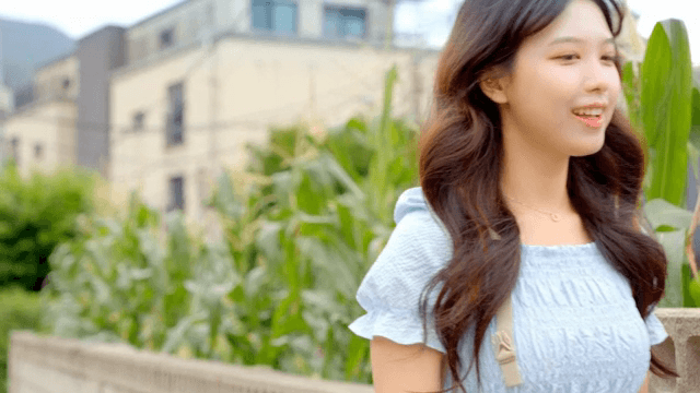 A woman walking by corn plants