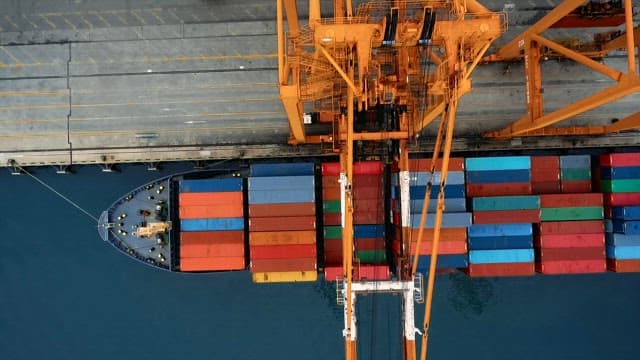 항구의 컨테이너가 쌓인 화물선과 크레인