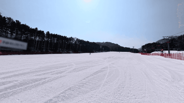 Skiers on snow-covered slope under clear sky