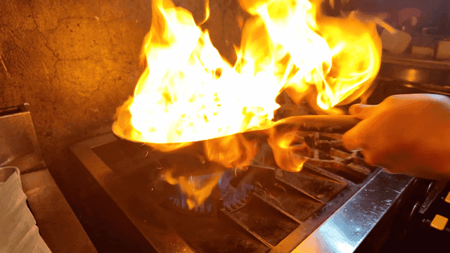 A pan with flames in a kitchen