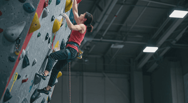 실내 클라이밍을 하는 여성