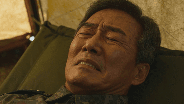 야전 침대에 누운 고통스러운 장교