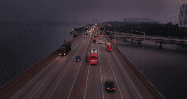 해질녘 바다 위 다리를 건너는 자동차들