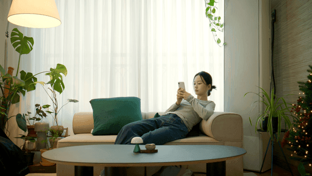 Woman relaxing on a sofa with a phone