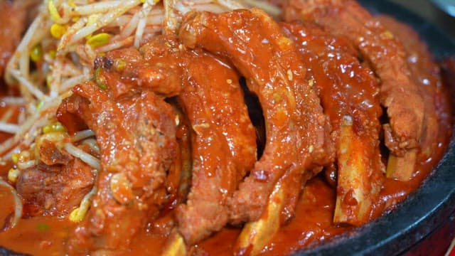 Steaming plate of spicy braised pork libs with bean sprouts