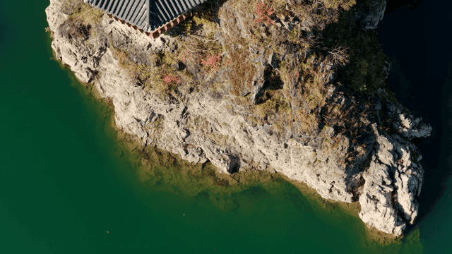 녹색 강 옆의 바위 절벽 위 한국 전통 정자