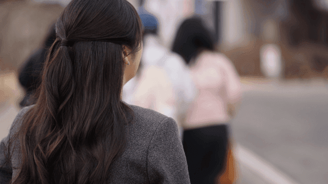 Back view of woman walking on busy street