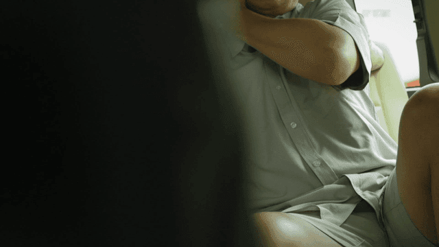 Man sitting in a vehicle wearing a shirt