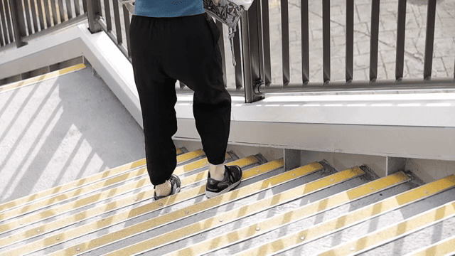 야외 계단을 힘겹게 내려가는 사람
