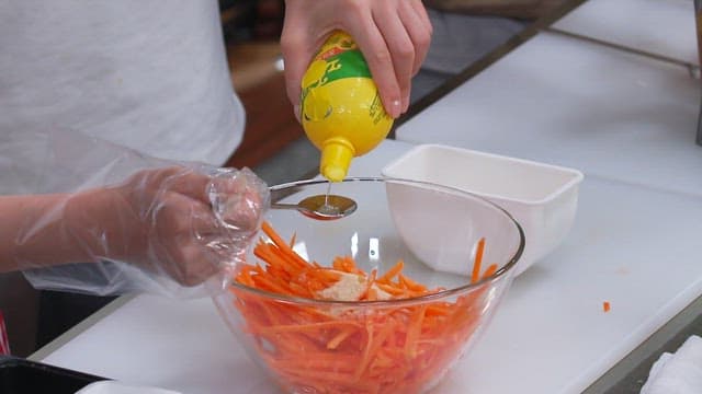 Preparing a Carrot Salad by Adding Lemon Juice