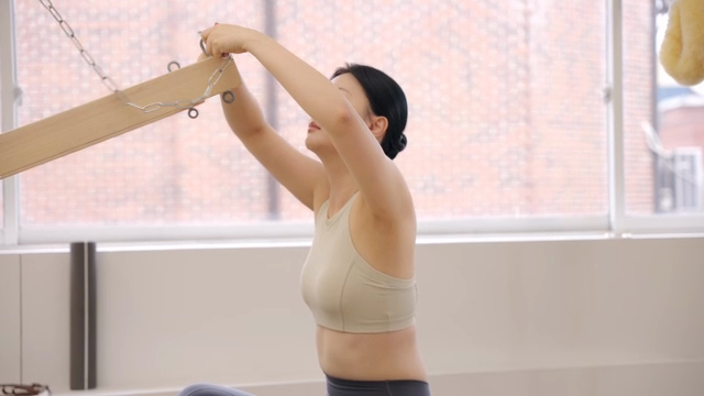 Woman adjusting pilates equipment indoors
