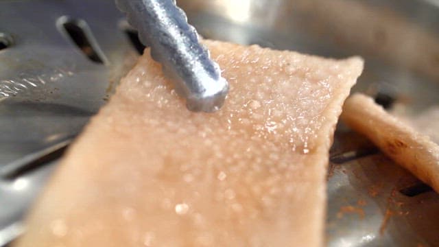 금속 그릴에 구워지는 돼지껍데기