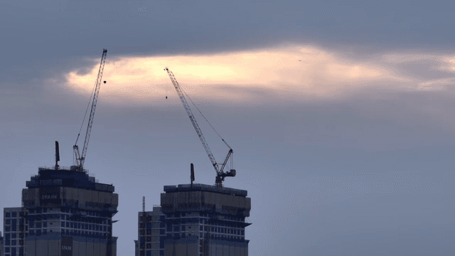 구름 낀 하늘 아래 건설 중인 고층 건물