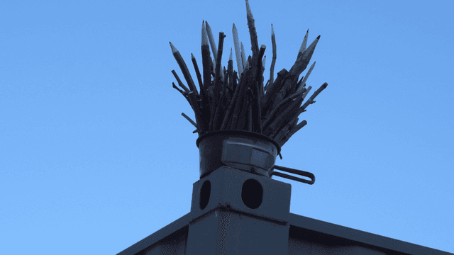 맑은 하늘 아래 나뭇가지 연필 조각품