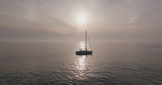 Yacht sailing on a calm sea at sunset