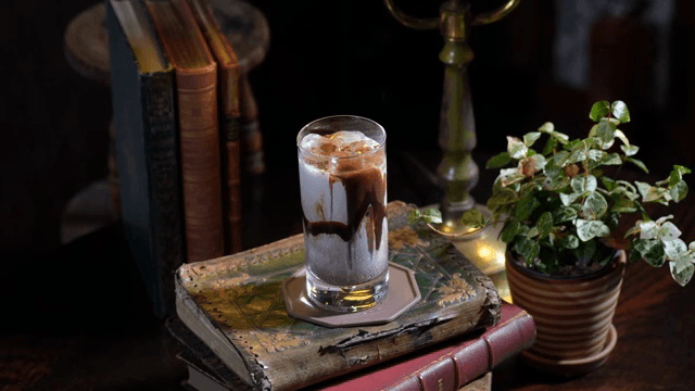 Pouring chocolate syrup into iced milk