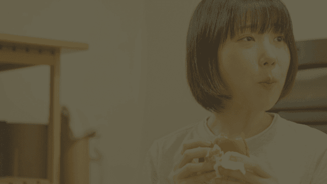 실내에서 햄버거를 즐기는 젊은 여성