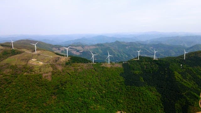 Wind turbines on a lush green mountain range