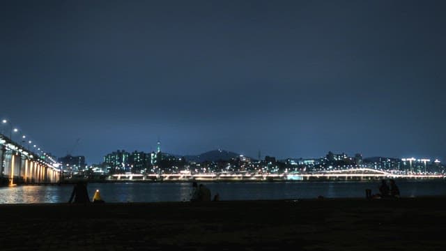 Riverside Night View with People Relaxing