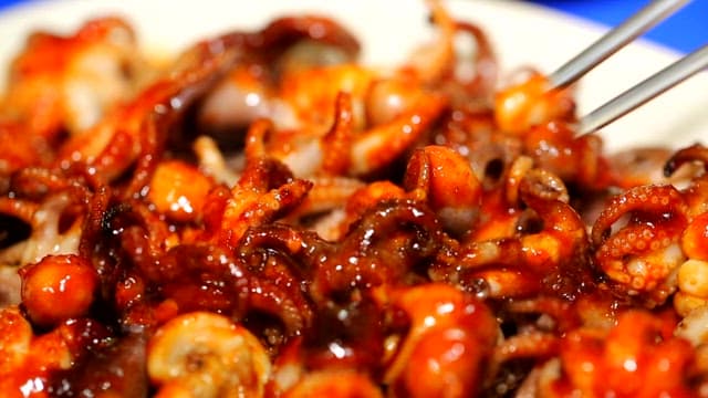 Grilled webfoot octopus picked up with chopsticks