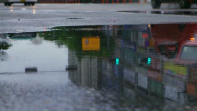 Reflection of City in a Puddle of Water on a Rainy Day