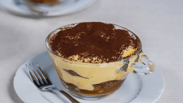 Tiramisu in a glass cup with a fork