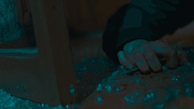 깨진 유리 사이로 손이 뻗어 있는 장면