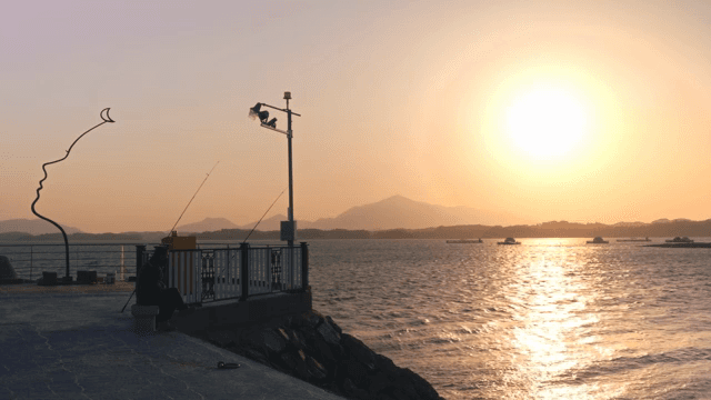 조각상과 함께 바다 위의 일몰 풍경