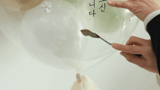 Hands decorating balloons with leaves