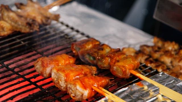 Skewered meat grilling over hot coals