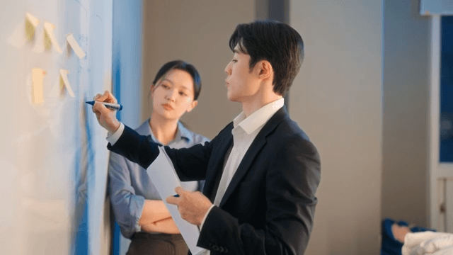 Two colleagues discussing at a whiteboard