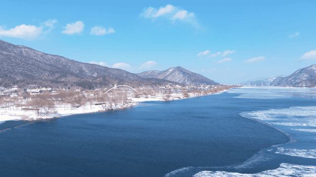 눈 덮인 산과 겨울 강의 고요한 풍경