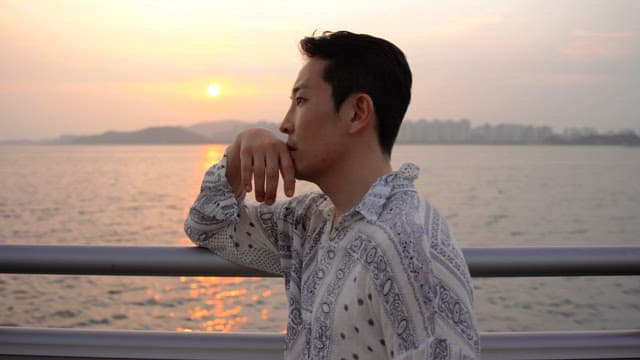 Man looking at the sea at sunset