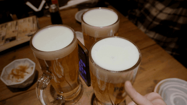 나무 테이블 위의 생맥주 세 잔