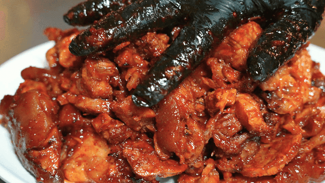 Hand holding seasoned spicy pig's trotters