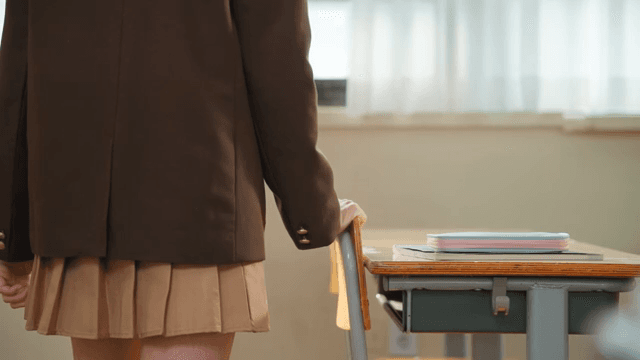 교실 창가에 서 있는 학생