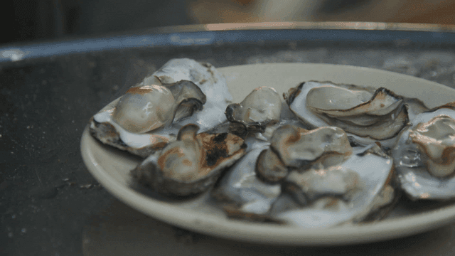 Hot sauce poured over oysters on plate