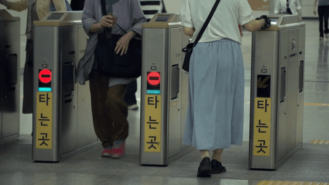 People passing through subway turnstiles