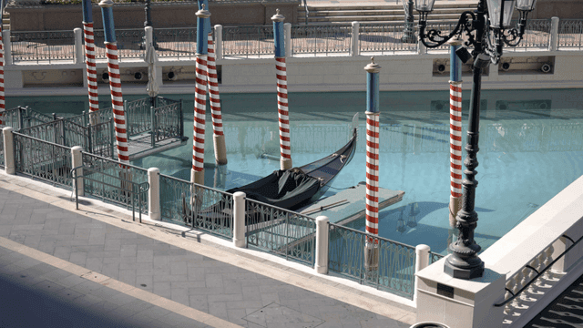 줄무늬 기둥이 있는 운하에 정박한 곤돌라