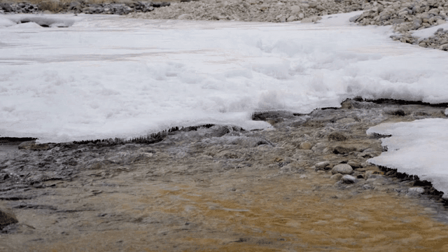 Flowing river with ice and rocks