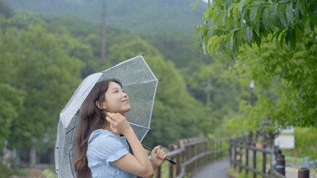 비 오는 날 우산을 쓴 여성