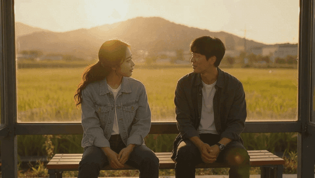 A couple talking at a bus stop at sunset