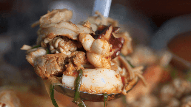 Monkfish seafood stew scooped to brim with ladle