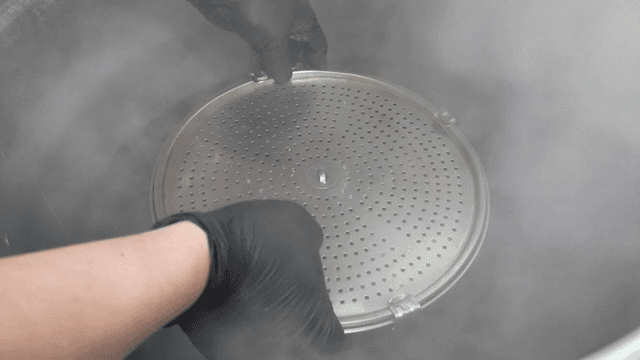 Broth strainer placed in metal pot