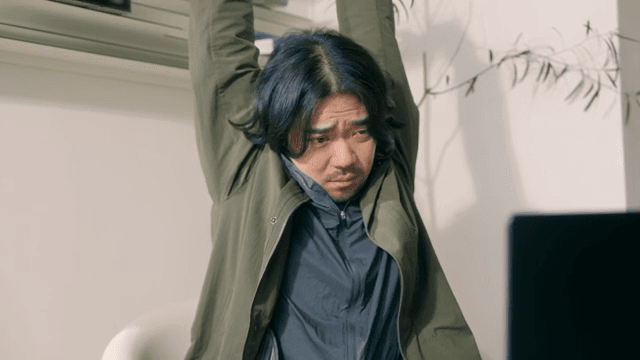 Man stretching and yawning at a desk