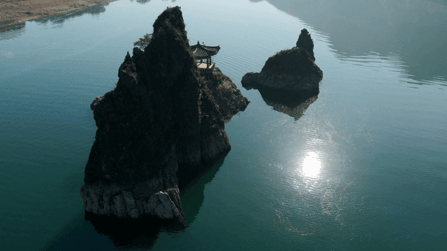 바위가 있는 고요한 강위 전통 정자